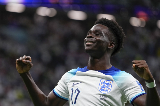 Bukayo Saka celebrates after scoring his side's third goal during a round of 16 match between England and Senegal at the 2022 FIFA World Cup at Al Bayt Stadium in Al Khor, Qatar on Sunday.  [AP/YONHAP]