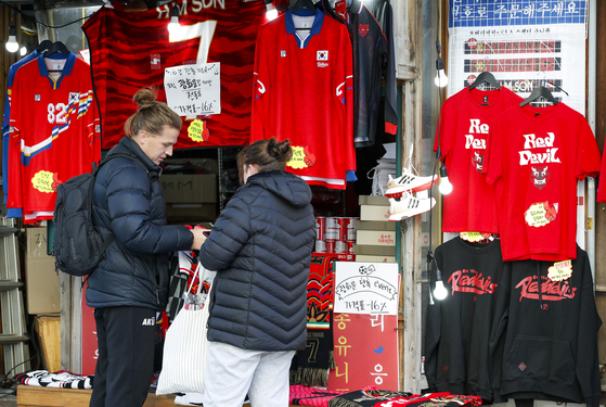 Foreign customers browse a section of Korean cheering items and uniforms at a store in Jongno District, central Seoul on Monday. [NEWS1]