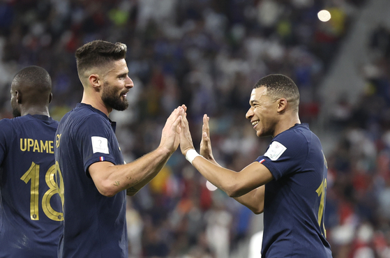 Oliver Giroud, left, celebrates with Kylian Mbappe during a round of 16 match between France and Poland at the 2022 FIFA World Cup at Al Thumama Stadium in Doha, Qatar on Sunday.  [XINHUA/YONHAP]