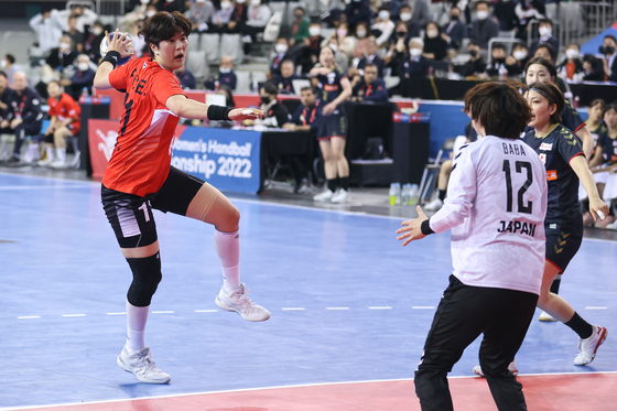 Ryu Eun-hee, left, plays the ball against Japan during the Asian Women’s Handball Championship final on Sunday at SK Olympic Handball Gymnasium in Songpa District, southern Seoul. Ryu scored 19 points alone, leading Korea to its sixth title in a row, and was named MVP of the match as the top scorer across both teams. Korea came from behind to win the title 34-29 in extra time. [YONHAP]