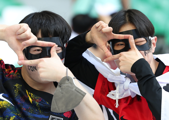 Football fans pose with Son Heung-min's signature ″click″ pose during the match against Portugal at the Qatar Al Rayyan Education City Stadium in Doha, Qatar on Friday. [YONHAP]
