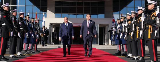 President Yoon Suk-yeol, right, walks with Vietnamese President Nguyen Xuan Phuc at a welcome ceremony at Yongsan presidential office in Seoul on Monday. [JOINT PRESS CORPS]
