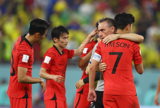 Korean national team head coach Paulo Bento embraces Son Heung-min after the round of 16 match between Brazil and Korea at the 2022 FIFA World Cup at Stadium 974 in Doha, Qatar on Monday. [REUTERS/YONHAP]