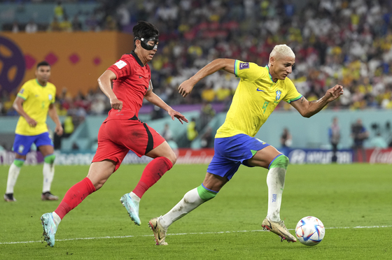 Richarlison of Brazil, right, vies with Son Heung-min during their round of 16 match at the 2022 FIFA World Cup at Stadium 974 in Doha, Qatar on Monday. [XINHUA/YONHAP]