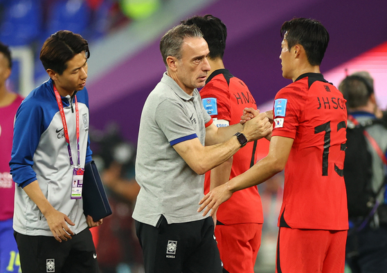 Korean national team head coach Paulo Bento shakes hands with Son Jun-ho after the round of 16 match between Brazil and Korea at Stadium 974, Doha, Qatar on Monday. [REUTERS/YONHAP]