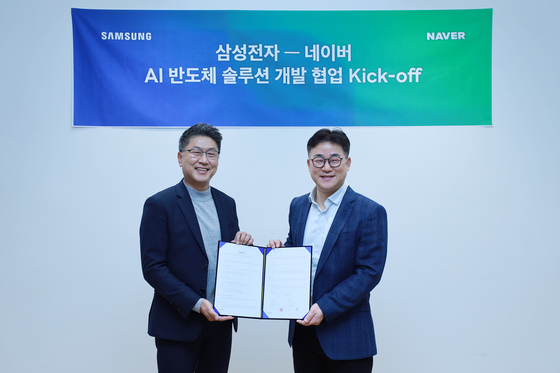 Han Jin-man, left, executive vice president of memory global sales and marketing at Samsung Electronics, and Chung Suk-geun, head of Naver's Clova division, pose for a photo during a signing ceremony held Friday in Seongnam, Gyeonggi. [NAVER]