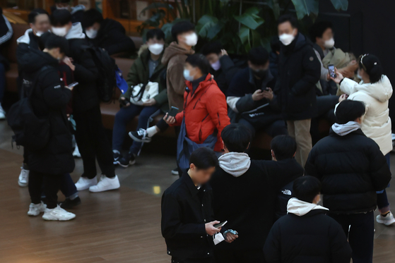 People in masks walk around a large shopping mall in downtown Seoul on Monday. [YONHAP]