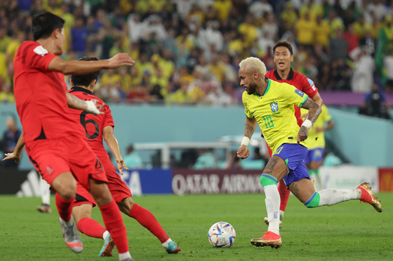 Neymar dribbles the ball against the Korean defense on Monday at a round of 16 match between Korea and Brazil at Stadium 974 in Doha, Qatar. [NEWS1]