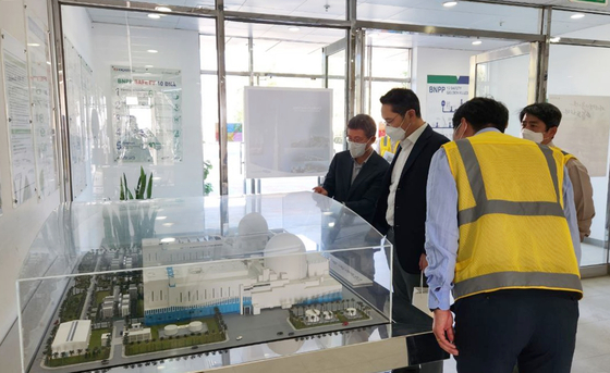 Samsung Electronics Executive Chairman Lee Jae-yong, second from left, looks at a model of the Barakah nuclear plant at the construction site in Al Dhafra, the United Arab Emirates, Tuesday. The Barakah plant, the country's first nuclear power plant, has been under construction since 2012 by the Team Korea consortium which includes Samsung C&T. Lee's visit to a construction site in the Middle East region is the first in three years since the newly-appointed executive chairman visited a subway construction site in Riyadh, Saudi Arabia, in 2019.[SAMSUNG ELECTRONICS] 