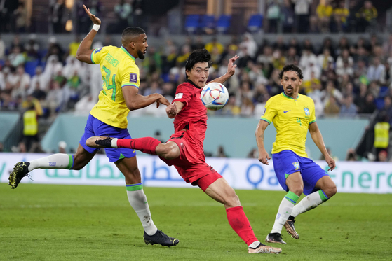 Brazil's Bremer, from left, Korea's Cho Gue-sung and Brazil's Marquinhos challenge for the ball during the World Cup round of 16 match between Brazil and Korea, at the Stadium 974, in Doha, Qatar on Monday. [AP/YONHAP]