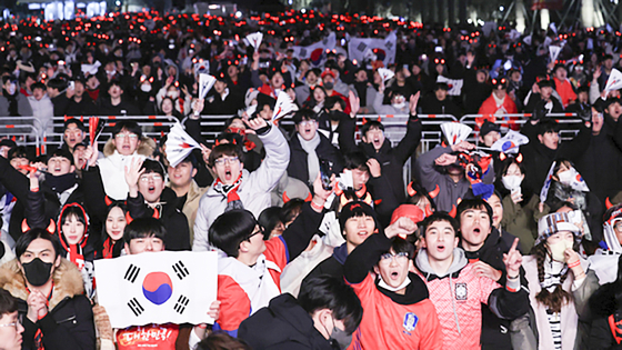 Football fans cheer on Gwanghwamun Square in central Seoul early Tuesday during the match between Korea and Brazil for the 2022 Qatar World Cup. [YONHAP]