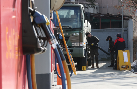 A military fuel tanker fills up fuel at a gas station in Seoul on Tuesday. Gas stations have been running out of fuel due to the cargo truck drivers' strike that has lasted for nearly two weeks. [YONHAP] 