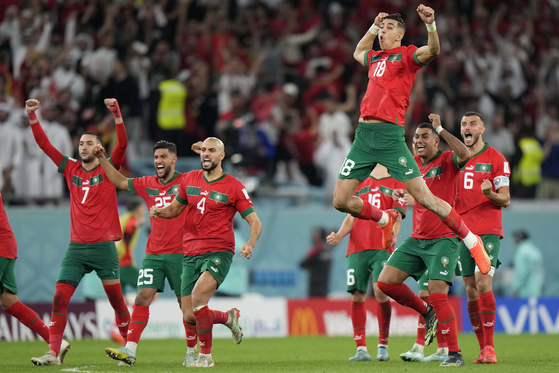 Morocco's Jawad El Yamiq, top, celebrates with teammates after the penalty shootout at the World Cup round of 16 match between Morocco and Spain at Education City Stadium in Al Rayyan, Qatar on Tuesday.  [AP/YONHAP]