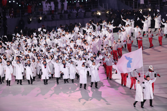 북한이 참가한 마지막 올림픽인 2018 평창동계올림픽 개막식에 남북한 선수단이 한반도기를 들고 함께 입장하고 있다. [YONHAP] 