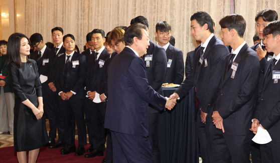 President Yoon Suk-yeol, center, greets the members of the South Korean national football team at a dinner banquet at the Blue House guest house in central Seoul Thursday evening. [PRESIDENTIAL OFFICE] 