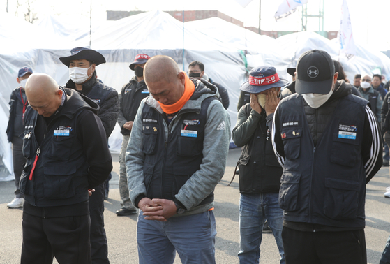 Cargo truck union leadership holds their head down after the members voted in favor of ending the strike at the inland container depot in Eulwang, Gyeonggi, on Friday. The strike lasted for 16 days, the longeset stretch since 2003. 