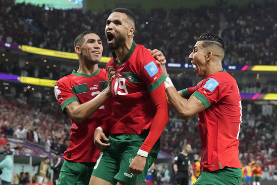 Morocco's Youssef En-Nesyri, center, celebrates after scoring his side's first goal during the World Cup quarterfinal match between Morocco and Portugal, at Al Thumama Stadium in Doha, Qatar, on Saturday. [AP/YONHAP]