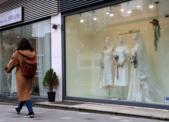 A shopper walks by a wedding dress shop in Ahyeon-dong, Mapo District, western Seoul, on March 17, 2022. [YONHAP]