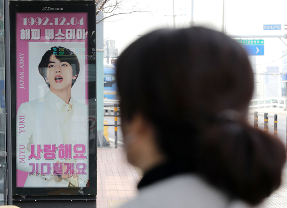 A bus sign celebrating BTS member Jin's birthday and wishing him a safe return from military service is seen in front of the HYBE building in Yongsan District, central Seoul, on Monday. [NEWS1]