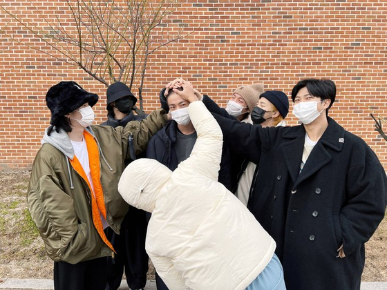 A BTS Twitter post shows members of BTS rubbing the head of Jin, who entered the army training center in Yeoncheon, Gyeonggi, on Tuesday. Jin, who is starting his 18-month mandatory military service, is the first member of the boy band to join the military. [BTS TWITTER/YONHAP] 