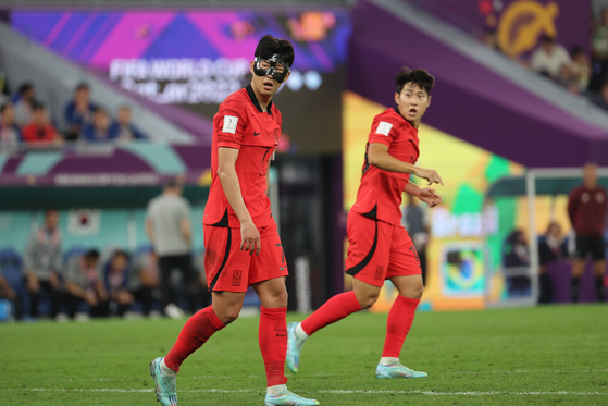 Son Heung-min, left and Lee Kang-in react during a round of 16 match between Brazil and Korea at the 2022 FIFA World Cup at Stadium 974 in Doha, Qatar on Dec. 6. [NEWS1]