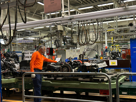Workers and robots work at Volvo Cars’ Torslanda manufacturing plant in Gothenburg, Sweden, on Dec. 5. [SARAH CHEA]  
