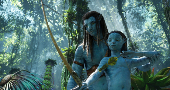 Jake Sully, portrayed by Sam Worthington, and his firstborn son Neteyam, portrayed by Jamie Flatters, bond in the forest of Pandora in “Avatar: The Way of Water.” [THE WALT DISNEY COMPANY KOREA]