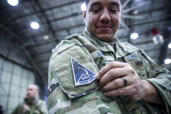 A service member of the South Korea-based United States Space Force (USSF) unit attaches the branch's badge to his right shoulder during the unit's launch ceremony at Osan Air Base in Pyeongtaek, Gyeonggi on Wednesday. [JOINT PRESS CORPS]