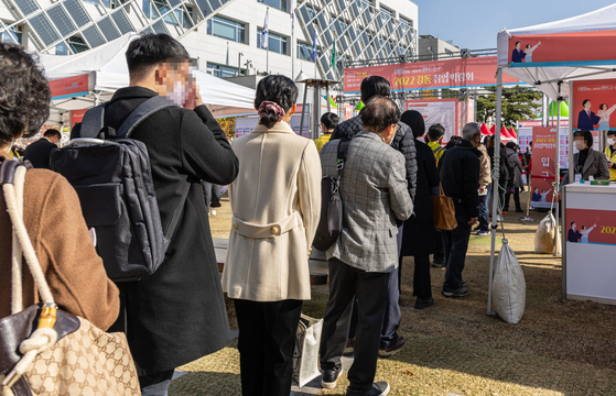 Job seekers wait in line at a job fair held in Gangdong District, eastern Seoul, on Nov. 16. [YONHAP]