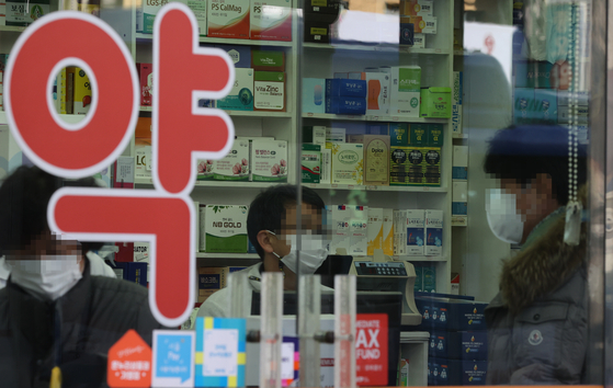 People are seen at a pharmacy in downtown Seoul on Wednesday. [YONHAP]