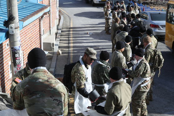 Soldiers from the 210th field artillery brigade of the ROK-US Combined force’s 2nd Infantry Division deliver coal briquettes for heating to low-income households in Dongducheon, Gyeonggi, on Wednesday. Some 5,000 briquettes were given to the needy. [YONHAP]