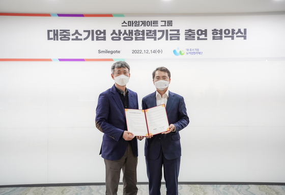 Smilegate signed an agreement with the Korea Foundation for Cooperation of Large&Small Business, Rural Affairs, to contribute 13 billion won ($10 million) to co-establish a fund for smaller companies. At left is Smilegate CEO Seong Jun-ho and at right, Kim Young-hwan, secretary general of the cooperation foundation. [SMILEGATE]