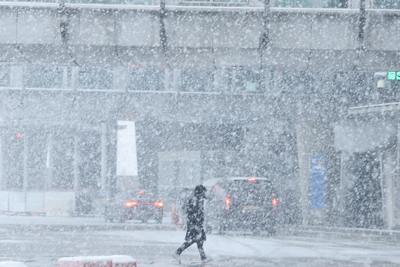 A person walks near Incheon International Airport on Thursday, as heavy snow was forecast to hit central regions of the country, including Seoul and some parts of the Gyeonggi, Gangwon and North Chungcheong regions. Eastern parts of Gyeonggi, central and southern inland areas of Gangwon, and northern parts of North Chungcheong may see over 10 centimeters of snow, according to the Korea Meteorological Administration. Snow will stop in Seoul in the afternoon, and by night for most parts of the country. [YONHAP] 