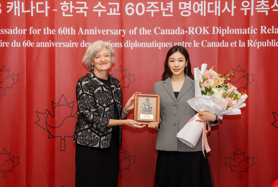 Tamara Mawhinney, charge d’affaires of the Canadian Embassy in Seoul, left, with newly-appointed honorary ambassador of Canada to Korea, Olympic gold medalist figure skater Kim Yuna, right, at the embassy in Seoul during a ceremony on Monday. Kim was appointed on the occasion of the 60th anniversary of relations between Canada and Korea next year. [EMBASSY OF CANADA IN KOREA]