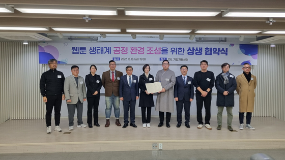 Officials from the Ministry of Culture, Sports and Tourism, the Fair Trade Commission, webtoon companies and creators' associations stand for photo after signing a non-binding agreement at the CKL Business Center in central Seoul, Friday. [YOON SO-YEON]