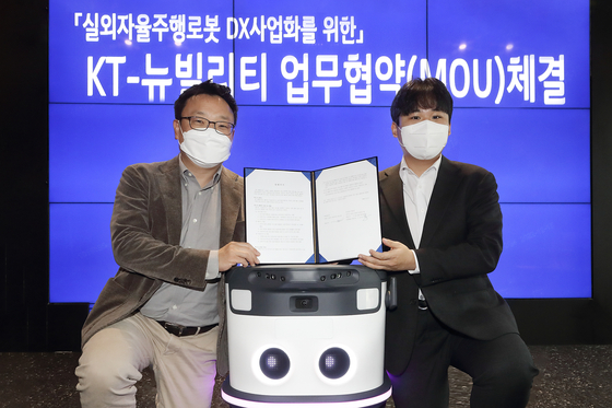 Lee Sang-ho, left, head of KT’s AI Robot business division, and Lee Sang-min, Neubility CEO, pose during a signing ceremony at KT's office building in Songpa District, southern Seoul. [KT]