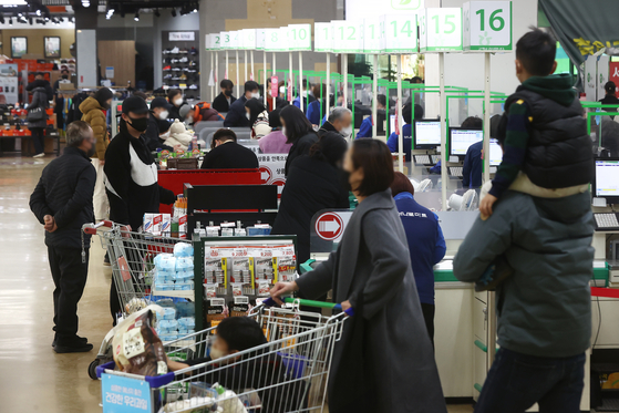 People purchase groceries at a discount mart in Seoul on Dec. 11. [YONHAP]