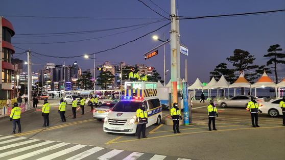 Police officers test controlling the crowd by standing on a police car and instructing people ahead of the Busan Fireworks Festival on Thursday. [YONHAP] 