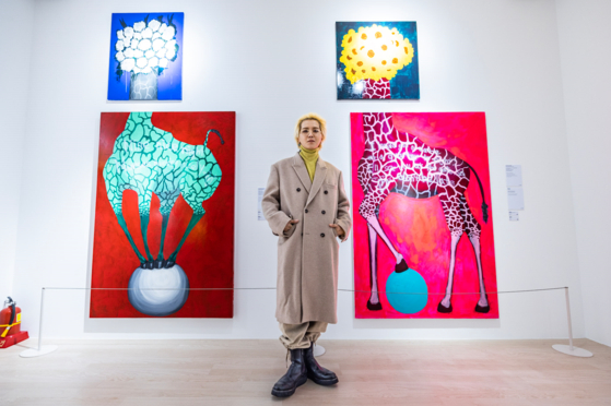 Mino from boy band Winner poses with his paintings at his first solo show "Thanking You- Ohnim" at stART PLUS gallery in Seongdong District, eastern Seoul, on Thursday. [START PLUS]