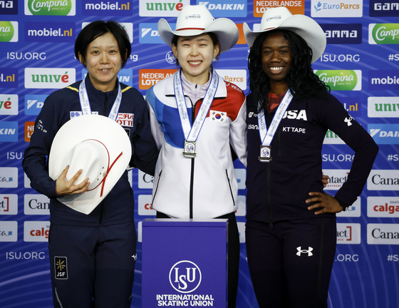 Kim Min-sun, center, celebrates her victory with second-place finisher Japan's Miho Takagi, left, and third-place finisher Erin Jackson of the United States, on the podium following the women's 500-meter competition at the ISU World Cup speed skating event in Calgary, Alberta, on Friday. [AP/YONHAP]