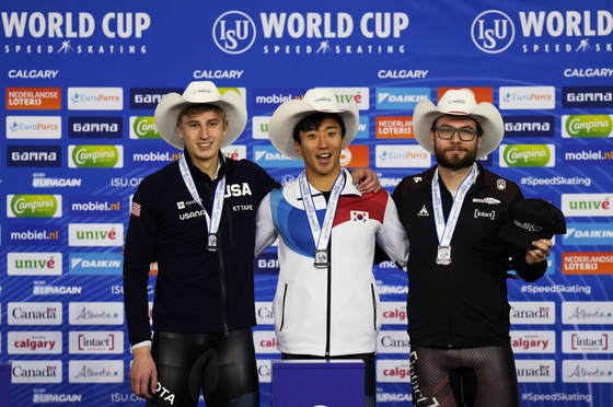 Kim Jun-ho, center, celebrates his gold medal with Jordan Stolz of the United States, left, who won silver and Laurent Dubreuil of Canada, right, who won bronze in the men's 500-meter at the ISU Speed Skating World Cup in Calgary, Canada, on Saturday. [EPA/YONHAP]