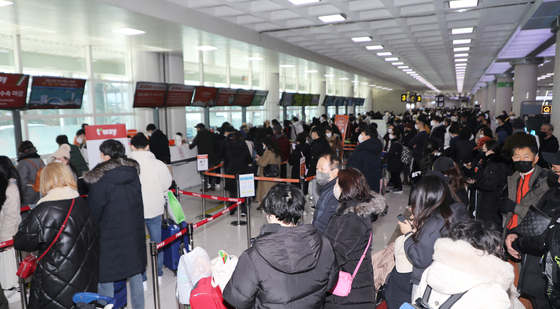 Jeju International Airport bustles with travelers as dozens of flights scheduled for Sunday were canceled or delayed due to the southern resort island of Jeju and other areas being hit by heavy snow and strong winds. [NEWS1]