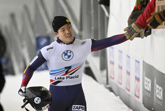 Jung Seung-gi is greeted in the finish area after the second run of the men's skeleton World Cup race on Friday in Lake Placid, New York. After the two runs, Jung finished third with a total time of 1:48.40. [AP/YONHAP]