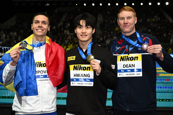 Hwang Sun-woo, center, celebrates winning the gold medal in the men's 200-meter freestyle final at the 2022 FINA World Swimming Championships alongside second placed David Popovici of Romania, left, and third placed Tom Dean of Britain at the Melbourne Sports and Aquatic Centre in Melbourne. [EPA/YONHAP]