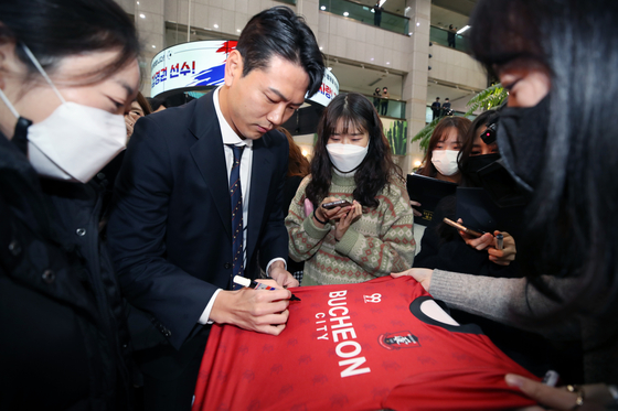 Veteran Korean defender Kim Young-gwon signs autographs in Bucheon, Gyeonggi on Monday. Kim, who recently returned from the 2022 Qatar World Cup, visited the Seoul satellite city to meet with Mayor Cho Yong-ik and talk to fans. Kim spent his teenage years in Bucheon and his family still live there. His father runs the Kim Young-gwon Football Club in the city and is a director at the Bucheon Sports Association for the Disabled.  [NEWS1]