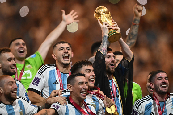 Argentina captain Lionel Messi lifts the FIFA World Cup Trophy as he celebrates with teammates after winning the 2022 Qatar World Cup final against France at Lusail Stadium in Doha on Dec. 18.  [AFP/YONHAP]