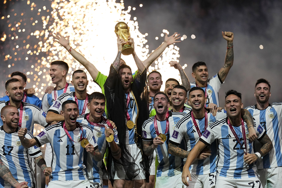 Argentina's Lionel Messi lifts the trophy after winning the World Cup in Qatar on Sunday.  [AP/YONHAP]