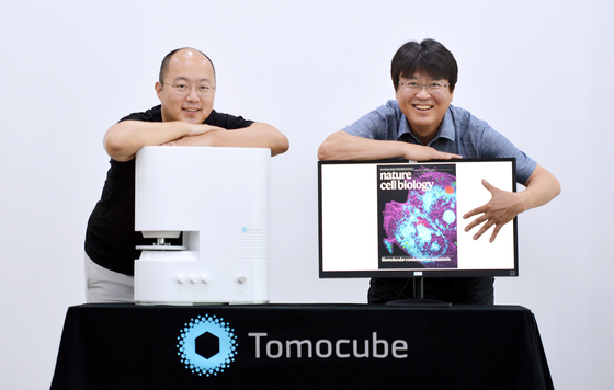 Tomocube CEO Park Yong-keun, left, poses with the company's microscope at its office in Daejeon. [KIM SEONG-TAE]