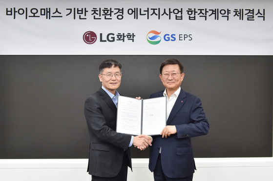 GS EPS CEO Chung Chang-soo, left, and No Guk Rae, head of LG Chem's petrochemical division, pose for a photo during a contract signing ceremony at the LG Twin Tower in western Seoul on Tuesday. [LG CHEM]