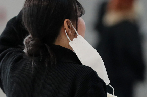 A passerby takes off her mask temporarily at the Incheon airport on Dec. 9. [NEWS1] 